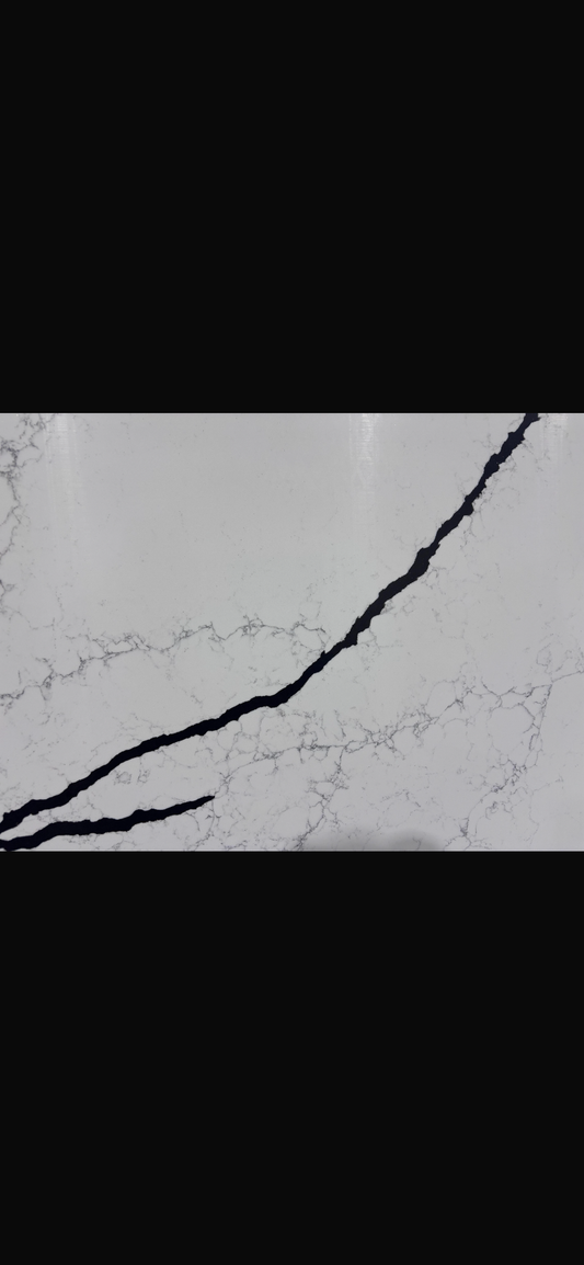 Close-up of a quartz surface with a black veins running through it.