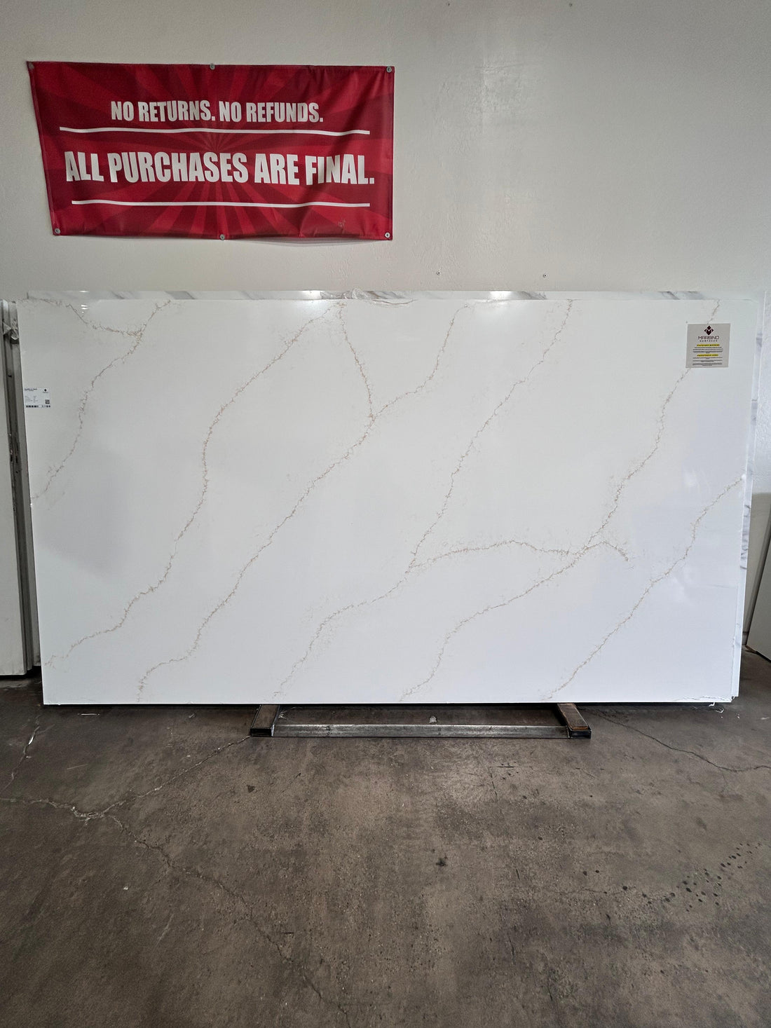 Naurelle Gold super jumbo quartz slab with a white background and soft brown and gold veining