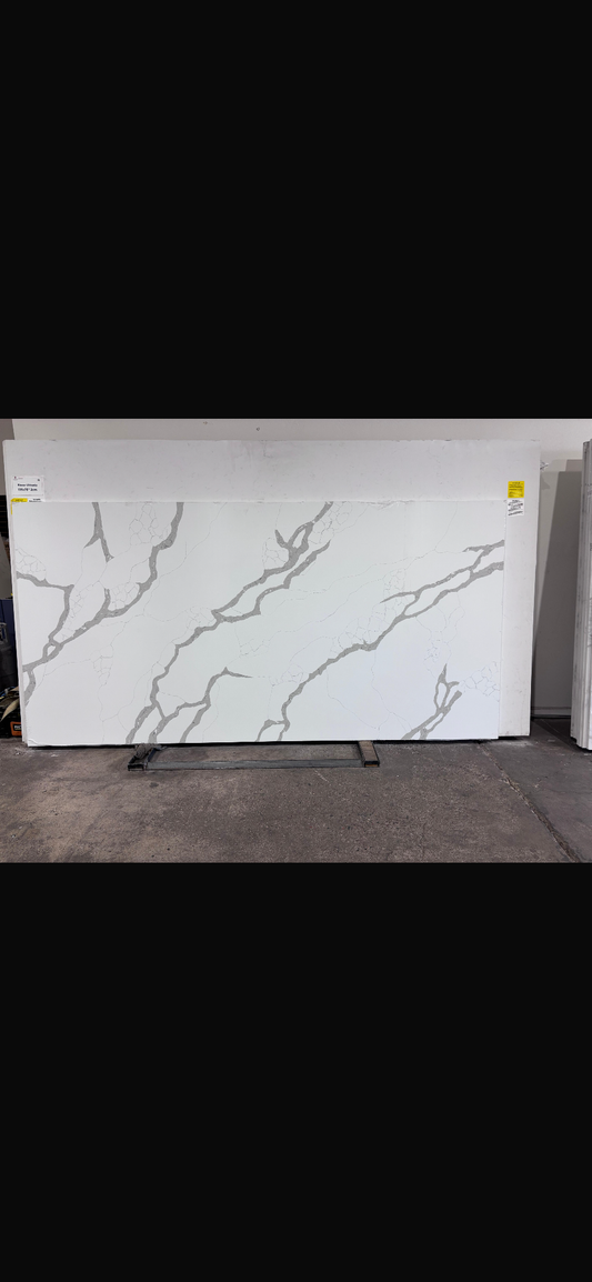 White quartz slab with gray veining on a stand against a white background