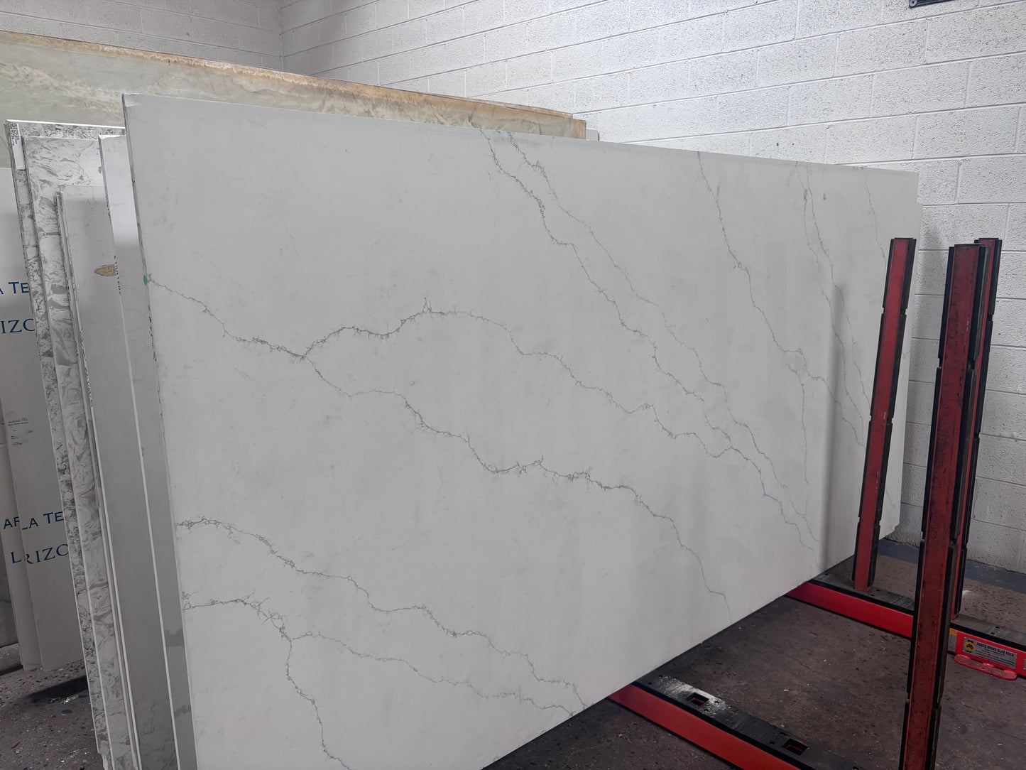 Large white marble slab with gray veining on pole rack