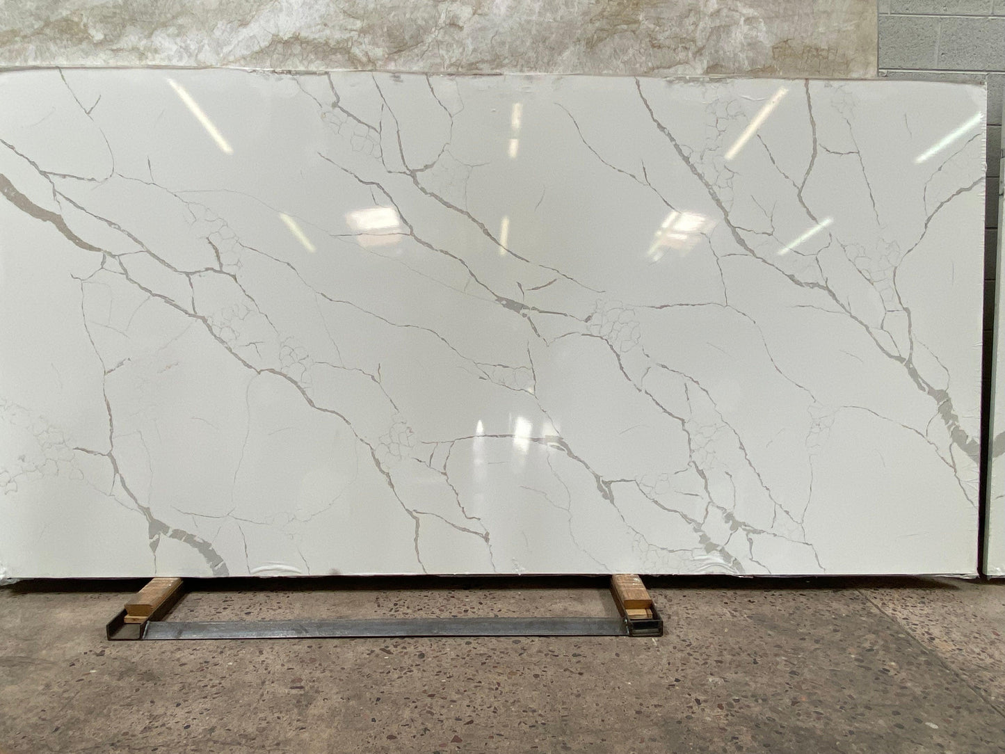 Polished 2CM White slab with prominent gray veins.